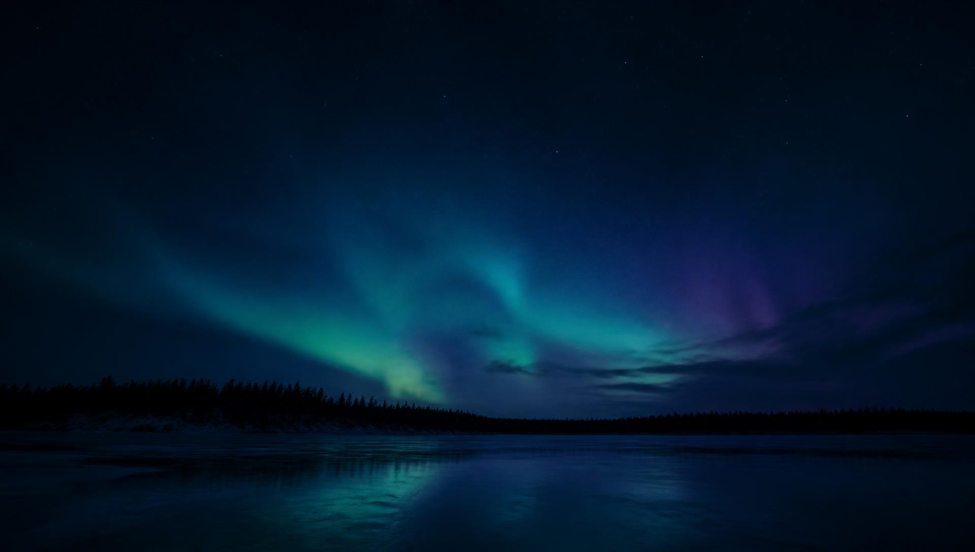 Northern lights over a quiet frozen Canadian lake at night